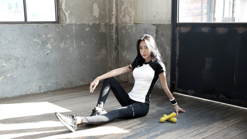woman in black tank top and black leggings sitting on floor